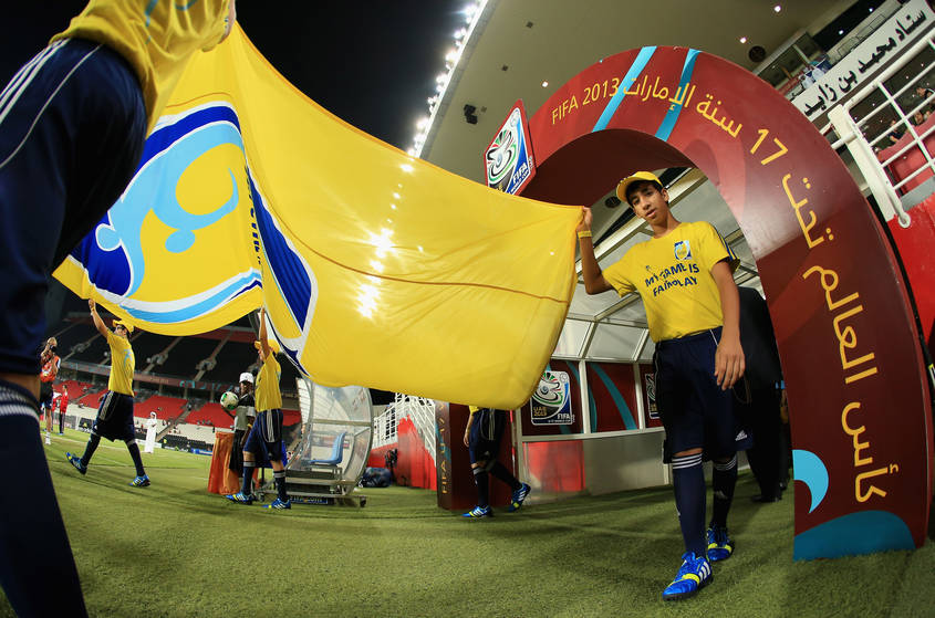 ABU DHABI, UNITED ARAB EMIRATES - OCTOBER 28:  The FIFA flags are carried to the pitch during the FIFA U-17 World Cup UAE 2013 Round of 16 match between Brazil and Russia at the Mohamed Bin Zayed Stadium on October 28, 2013 in Abu Dhabi, United Arab Emirates.  (Photo by Richard Heathcote - FIFA/FIFA via Getty Images)