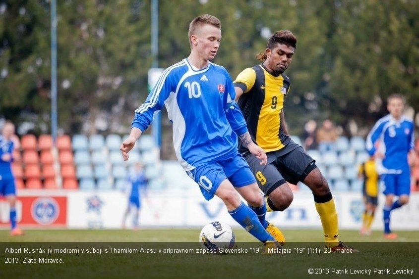 Albert Rusnák (v modrom) v súboji s Thamilom Arasu v prípravnom zápase Slovensko "19" - Malajzia "19" (1:1). 23. marec 2013, Zlaté Moravce.