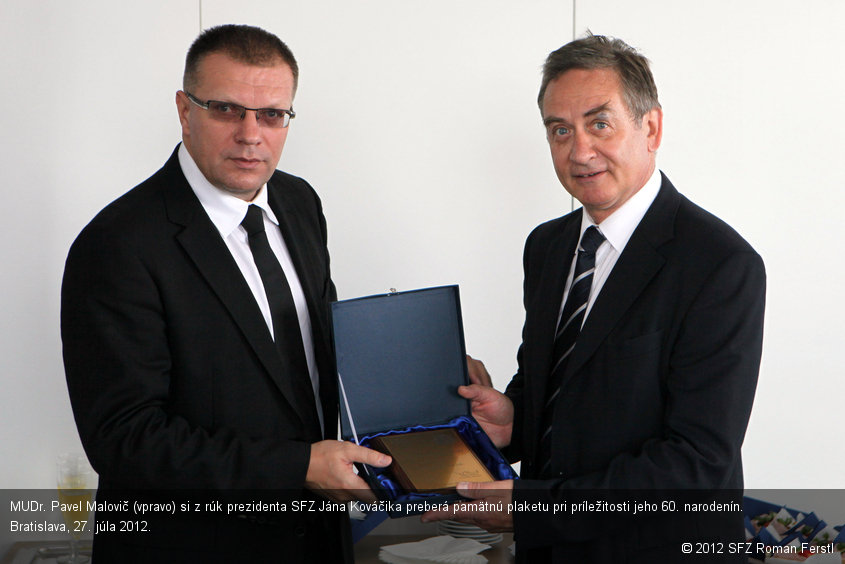 MUDr. Pavel Malovič (vpravo) si z rúk prezidenta SFZ Jána Kováčika preberá pamätnú plaketu pri príležitosti jeho 60. narodenín. Bratislava, 27. júla 2012.