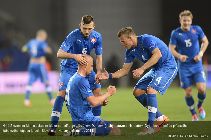 Hráč Slovenska Martin Jakubko (dole) sa teší z gólu s Jánom Ďuricom (druhý sprava) a Norbertom Gyömbérom počas prípravého futbalového zápasu Izrael - Slovensko. Netanya, 5. marca 2014.