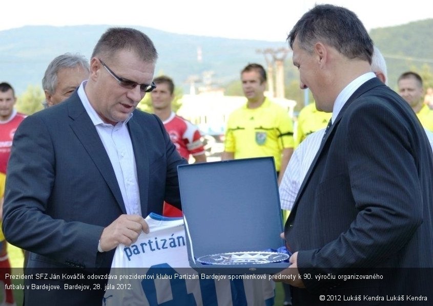 Prezident SFZ Ján Kováčik odovzdáva prezidentovi klubu Partizán Bardejov spomienkové predmety k 90. výročiu organizovaného futbalu v Bardejove. Bardejov, 28. júla 2012.