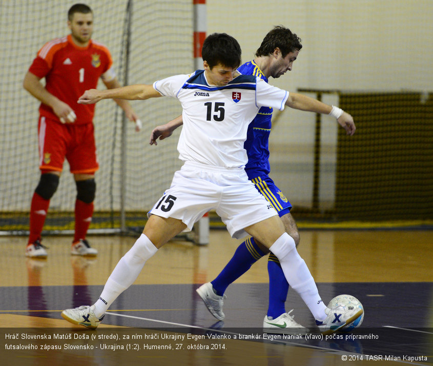 Hráč Slovenska Matúš Doša (v strede), za ním hráči Ukrajiny Evgen Valenko a brankár Evgen Ivaniak (vľavo) počas prípravného futsalového zápasu Slovensko - Ukrajina (1:2). Humenné, 27. októbra 2014.