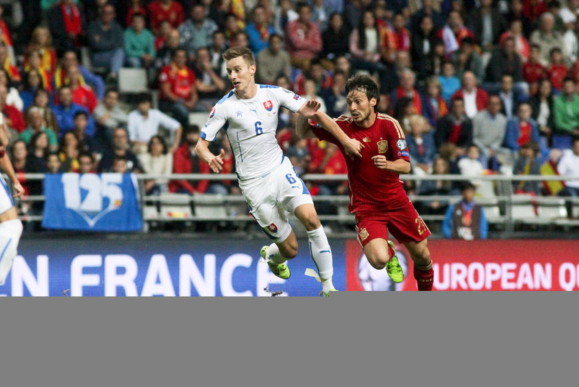 Ján Greguš (č.6) a David Silva v zápase kvalifikačnej C - skupiny o postup na EURO 2016 Španielsko -  Slovensko (2:0). Oviedo, 5. septembra 2015.