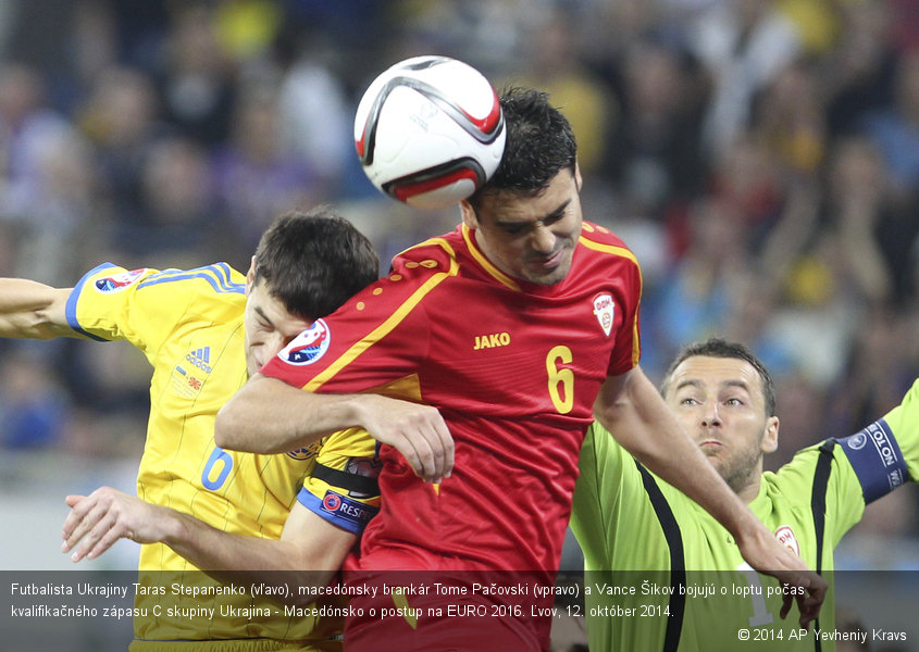 Futbalista Ukrajiny Taras Stepanenko (vľavo), macedónsky brankár Tome Pačovski (vpravo) a Vance Šikov bojujú o loptu počas kvalifikačného zápasu C skupiny Ukrajina - Macedónsko o postup na EURO 2016. Ľvov, 12. október 2014.