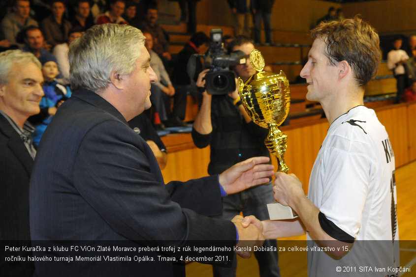 Peter Kuračka z klubu FC ViOn Zlaté Moravce preberá trofej z rúk legendárneho Karola Dobiaša za celkové víťazstvo v 15. ročníku halového turnaja Memoriál Vlastimila Opálka. Trnava, 4.december 2011.